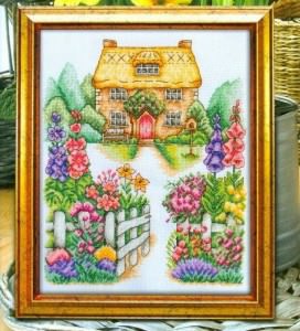 Вышитая крестом картина с домиком в цветах